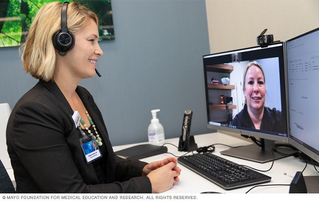 شخص يتحدث مع أحد أفراد فريق الرعاية الصحية عن طريق زيارة افتراضية عبر الفيديو.