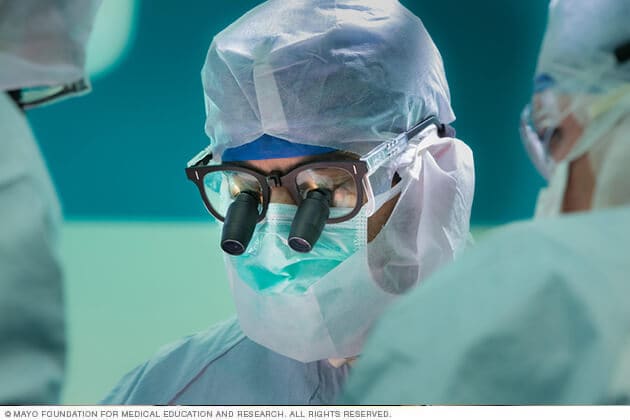 Un cirujano ortopédico oncólogo utiliza lentes de aumento durante una intervención.
