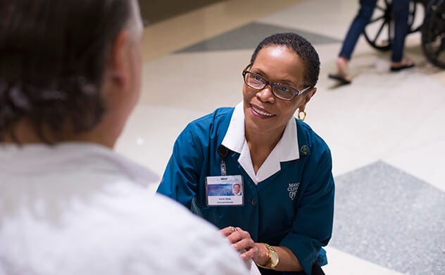 A Mayo Clinic volunteer in Florida helps a patient.