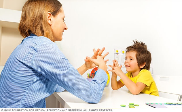 Child performing developmental exercises with therapist 