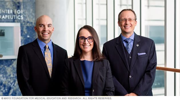 Tres médicos del personal de Salud Masculina de Mayo Clinic sonríen al saludar.