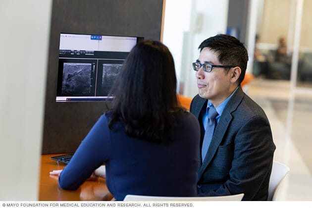 Melanoma Surgical Oncology team members discuss a patient's care needs.