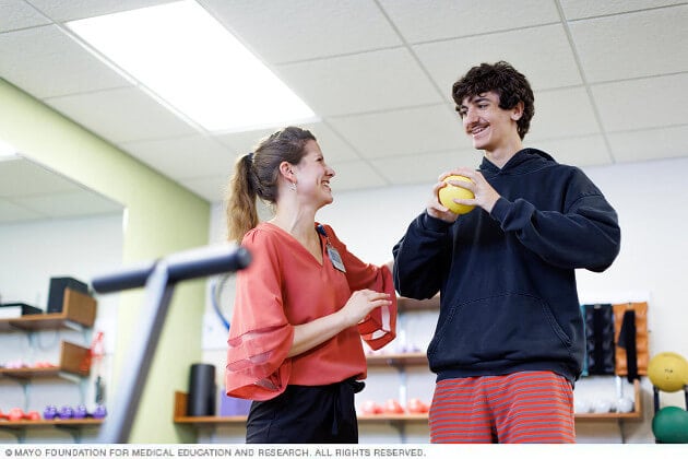 A group of young people dance during a group therapy session.