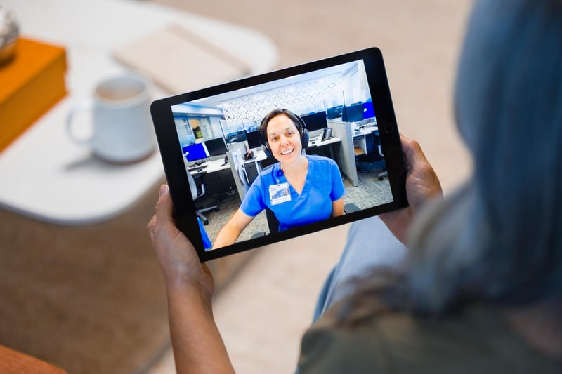 A Mayo Clinic registered nurse talks with a patient during a virtual visit, shown on a tablet held by the patient at home.