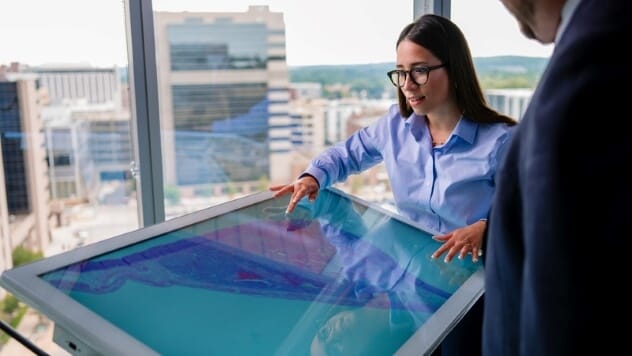 Digital pathologists review a large tablet together.