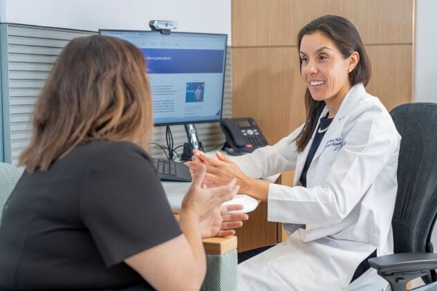 A bariatric center physician and patient discuss treatment options in an office.