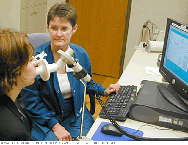 امرأة تستخدم مقياس التنفس بمساعدة فني