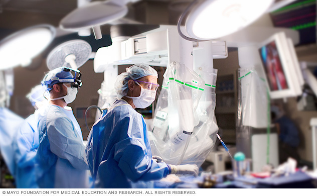 فريق جراحي عند طاولة العمليات أثناء إجراء جراحة القلب بمساعدة الروبوت