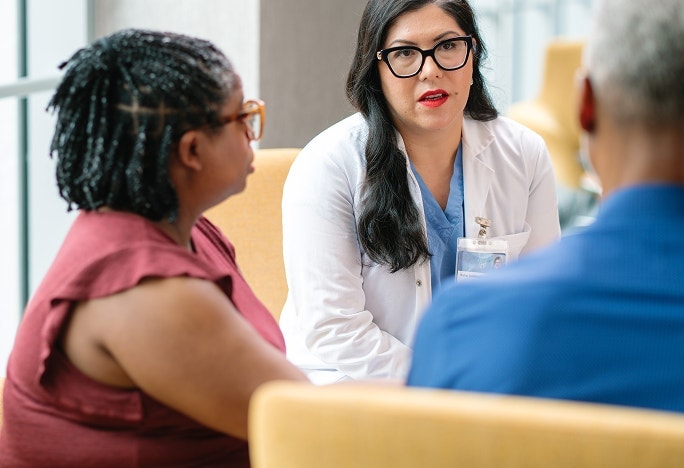 Female physician speaking to patient and caregiver