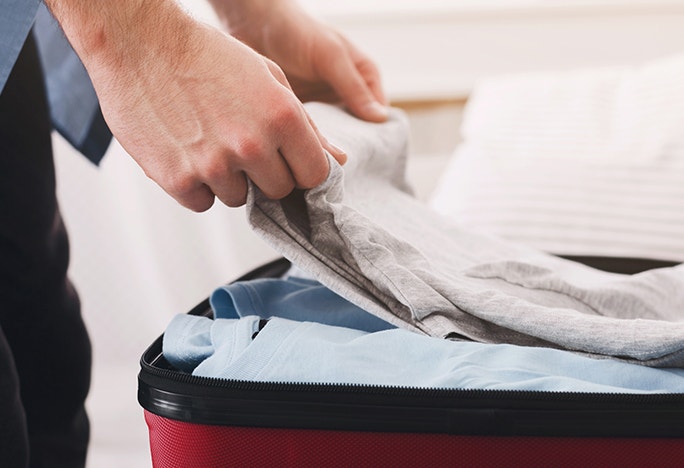 Closeup of person packing their suitcase