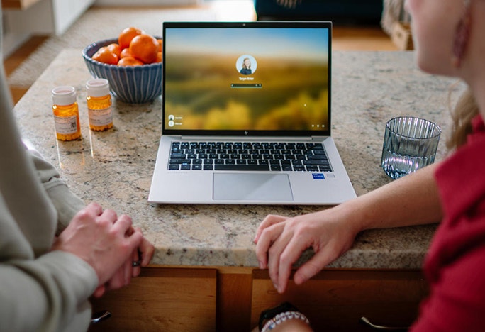 Patient and caregiver using their laptop at home