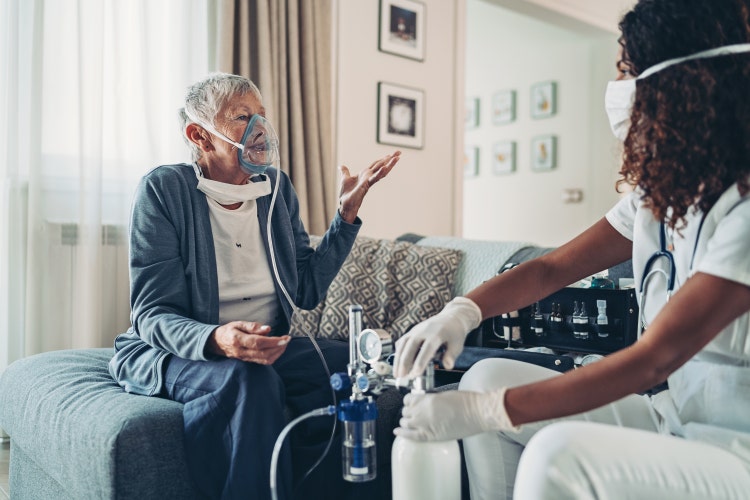 Older patient wearing an oxygen mask at home.