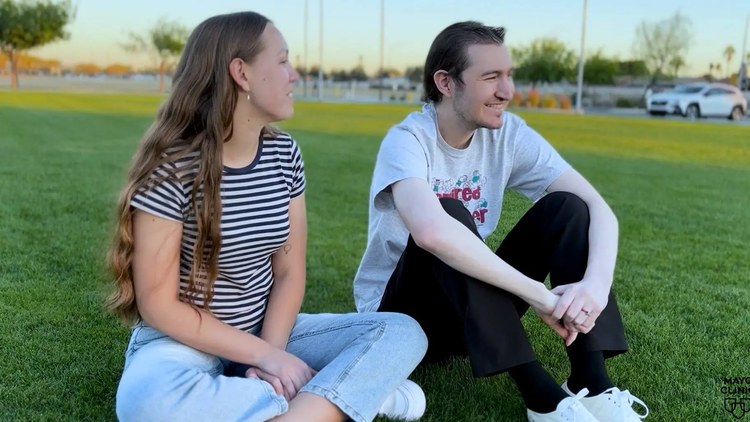 Young man and woman sitting outside