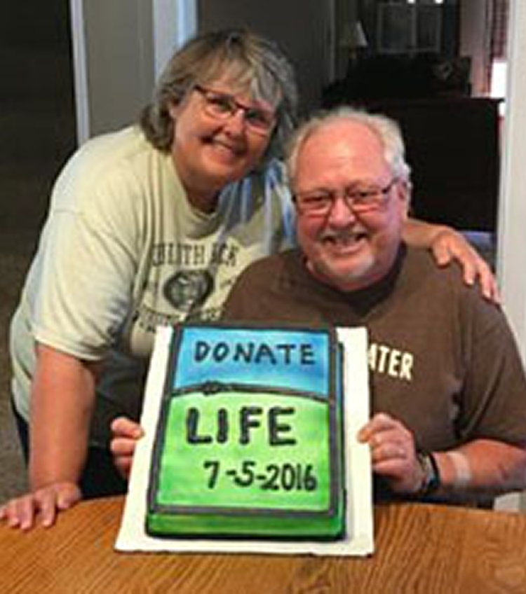 Caregiver and patient smiling with a Donate Life cake.