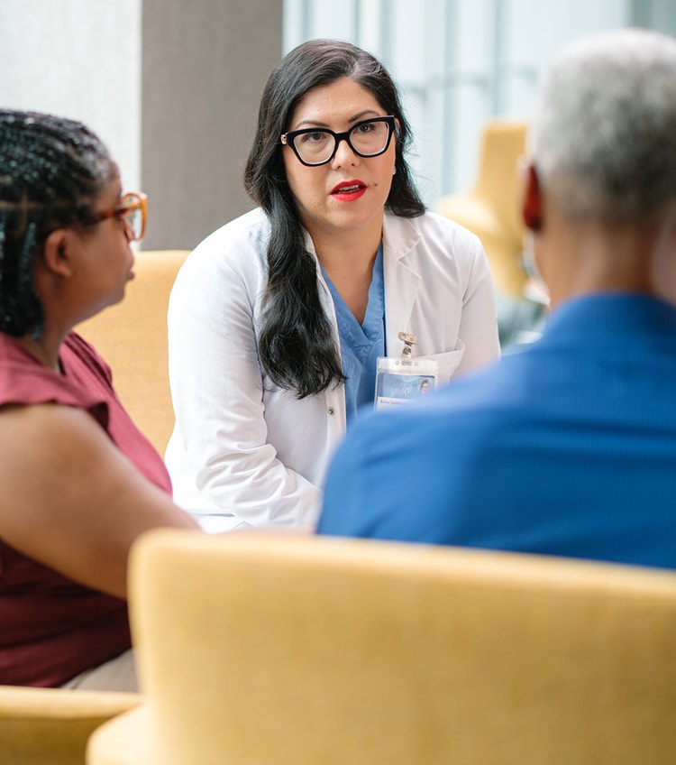 Female physician speaking to patient and caregiver.