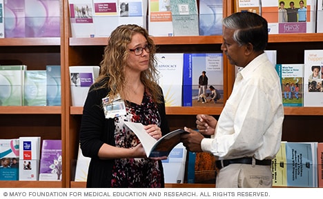 Un miembro del personal de educación sobre el cáncer de Mayo Clinic consulta con una persona sobre materiales educativos.